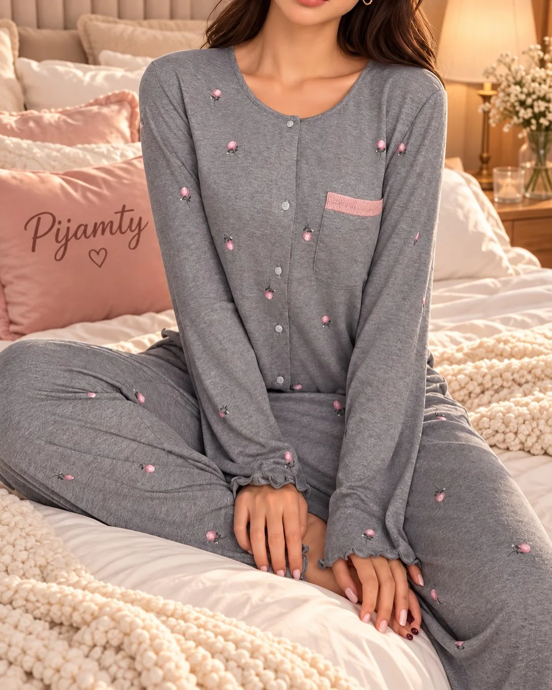 Close view of grey pajama buttons, pink rosebud motifs and ruffled sleeve cuffs